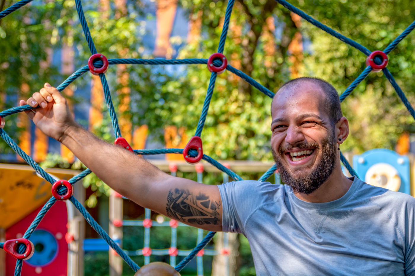 Portret de barbat care rade cu tatuaj pe mana